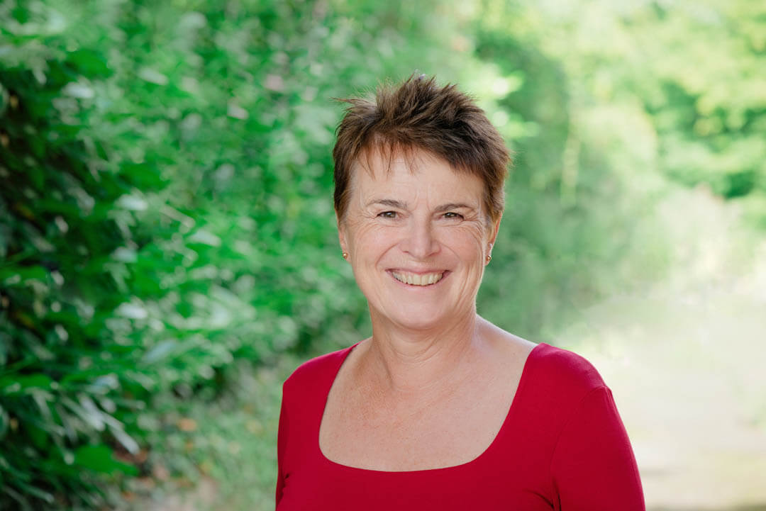 female doctor in red top smiling at the camera