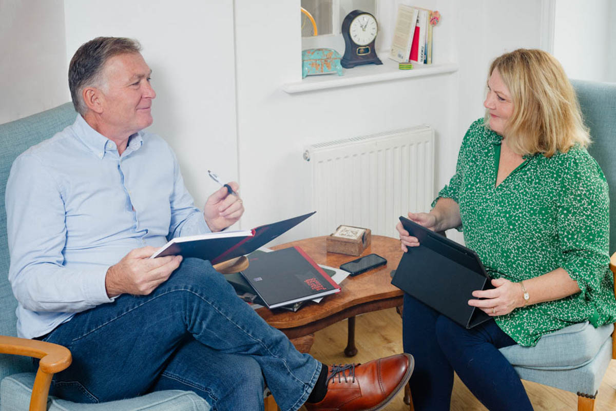 Professional photo of a coach talking to a client in their home