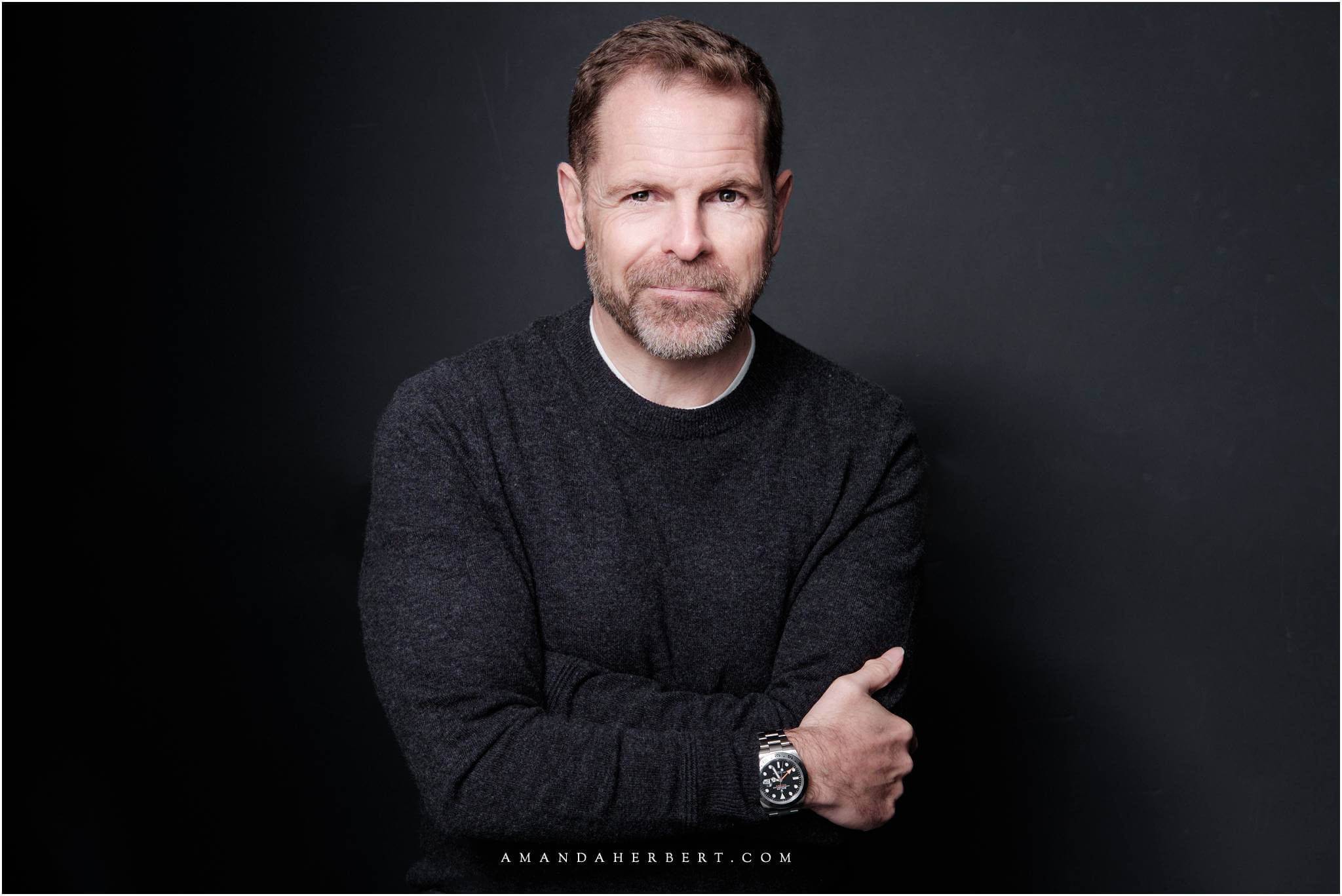 Corporate headshot of a confident man in a jumper, showcasing professional demeanor and approachability. Tips for corporate headshot photography.